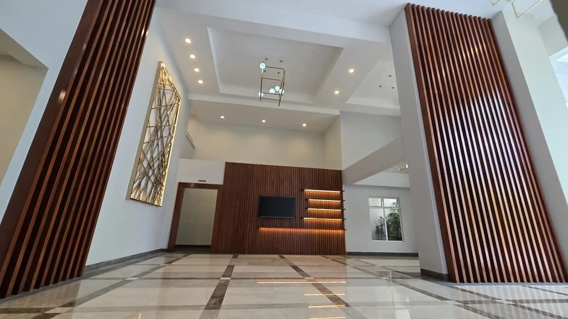 Double-height lobby with timber slat feature walls by Nano Build