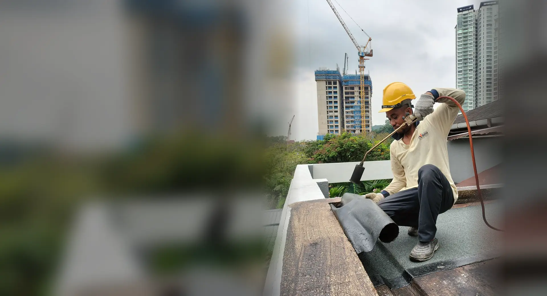 Nano Builders crew torching on a waterproofing membrane at a roof edge